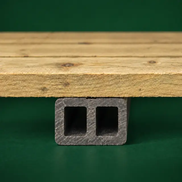 A timber floor board resting on a charcoal composite floor runner